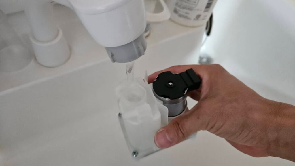 取り付ける前に風呂水ポンプの中へ水を入れているところ